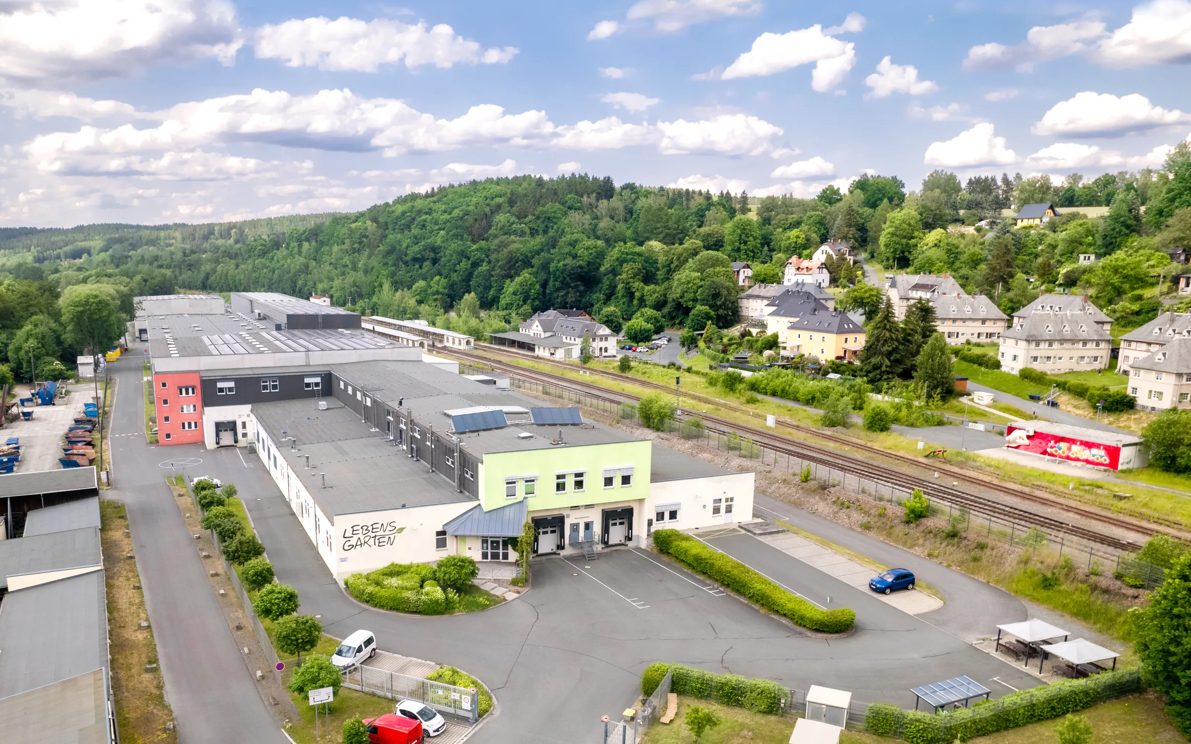 Luftaufnahme des Lebensgarten-Werks am Güterbahnhof Adorf mit Bahngleisen