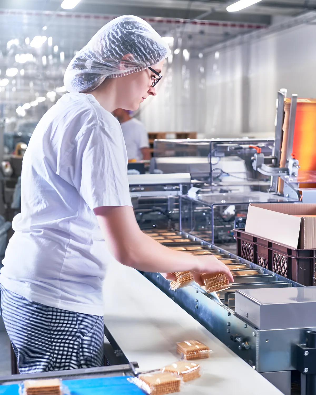 Mitarbeiterin verpackt Produkte an der Linie