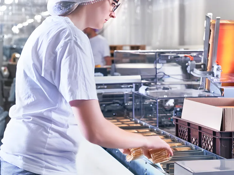 Mitarbeiterin verpackt Produkte an der Linie